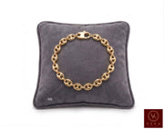 7mm puffed mariner link bracelet in 14K yellow gold displayed on a grey velvet pillow by Veka Jewelry