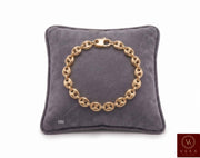 8mm puffed mariner link bracelet in 14K yellow gold displayed on a grey velvet pillow by Veka Jewelry