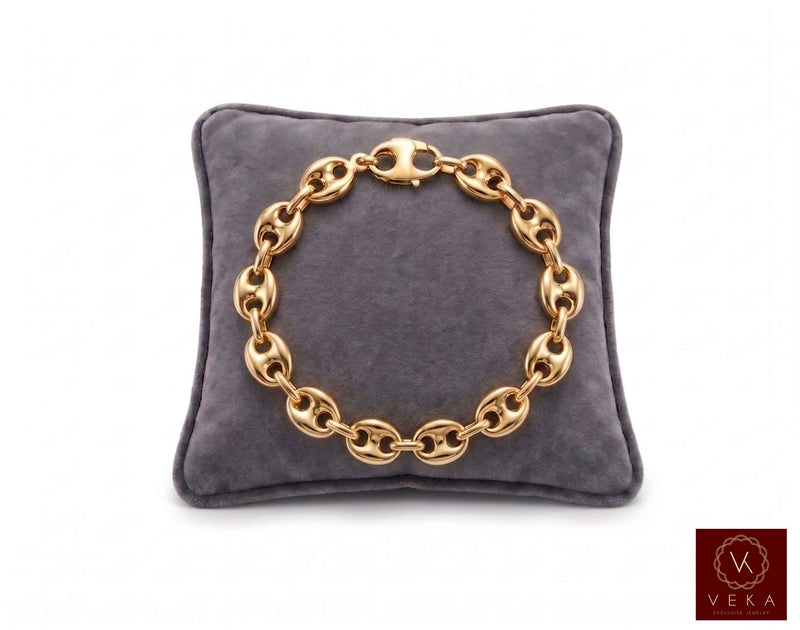9mm puffed mariner link bracelet in 14K yellow gold displayed on a grey velvet pillow by Veka Jewelry