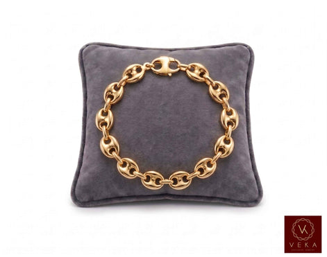 9mm puffed mariner link bracelet in 14K yellow gold displayed on a grey velvet pillow by Veka Jewelry