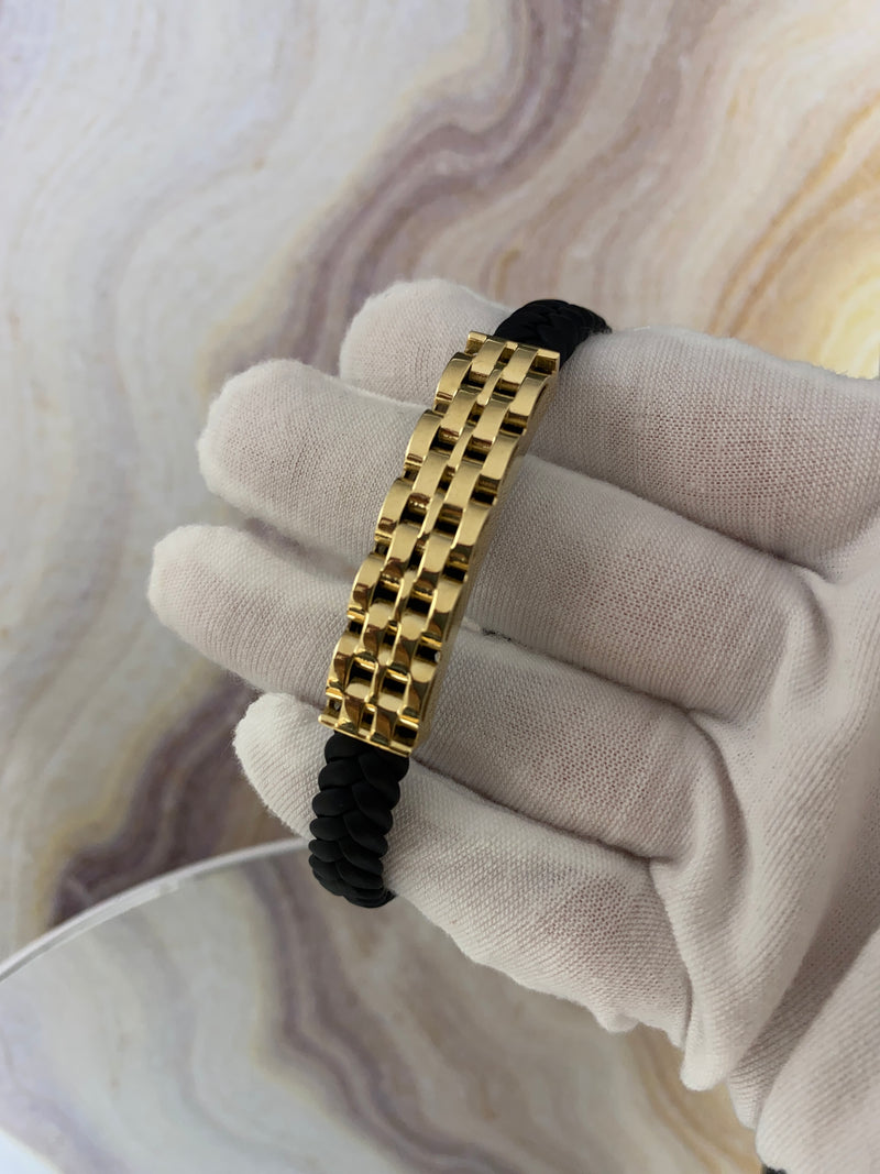 A 14 karat gold leather bracelet with a lobster lock clasp, crossed in a figure-eight style, displayed on a white golve.