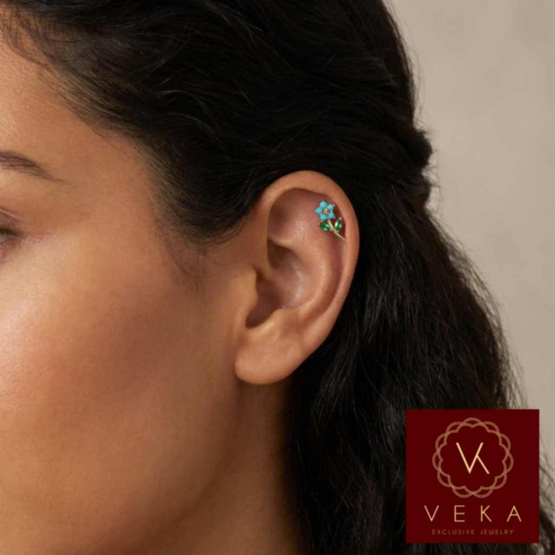 Close-up of a woman's ear wearing a floral cartilage piercing with Veka logo.