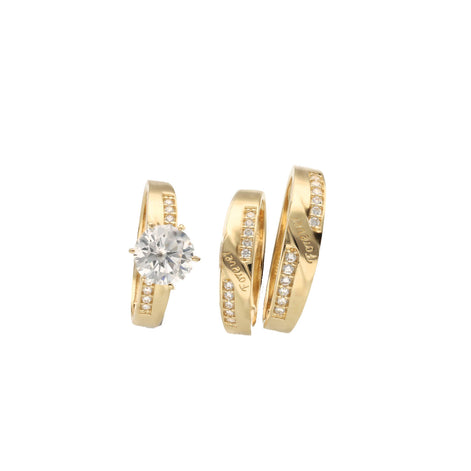 A set of three 14 karat gold rings with zirconia stones, including one engagement ring and two bands for women and men with the engraving Forever in both men and women band.
