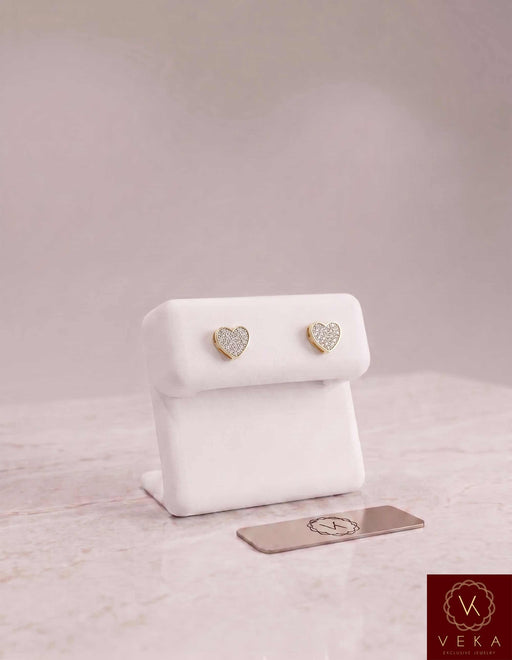 Luxury gray suede jewelry display showcase featuring a pair of 10K gold and natural diamond heart earrings from Veka Jewelry