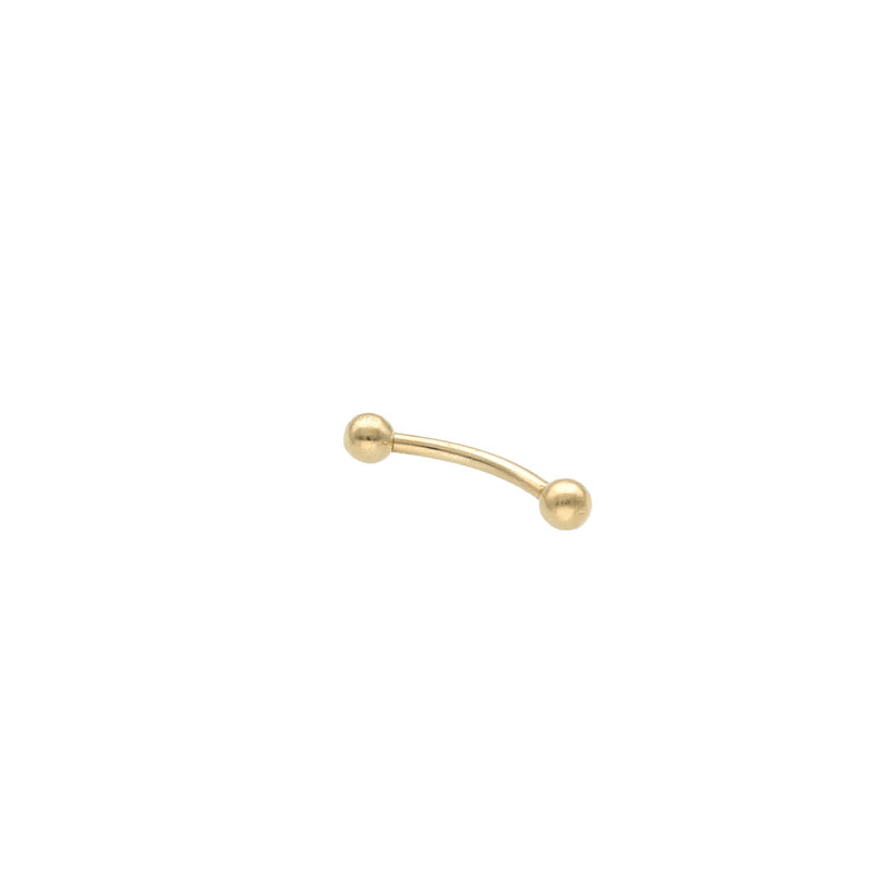 A 14 karat gold eyebrow piercing with a curved shape and balls at the end, presented on a white background.