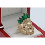 Close-up angled view of the Men's 14K Yellow Gold Indian Chief Ring (13.3g) by Veka Jewelry, featuring a detailed headdress set with emerald green marquise-cut synthetic stones and clear cubic zirconia accents, displayed in a red ring box