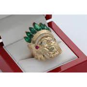 Close-up angled view of the Men's 14K Yellow Gold Indian Chief Ring (13.3g) by Veka Jewelry, featuring a detailed headdress set with emerald green marquise-cut synthetic stones and clear cubic zirconia accents, displayed in a red ring box