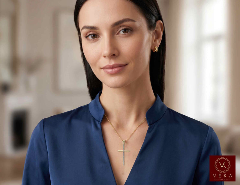 Female model wearing the 10K two-tone elongated cross pendant on a delicate gold chain.
