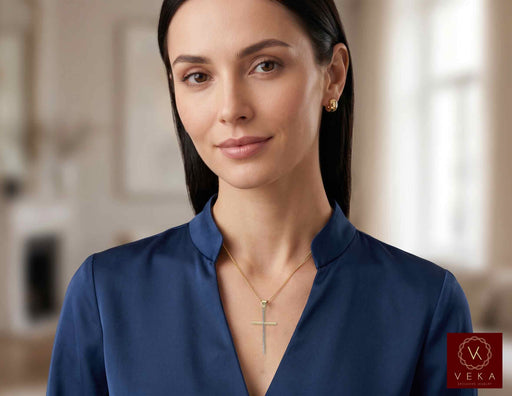 Female model wearing the 10K two-tone elongated cross pendant on a delicate gold chain.