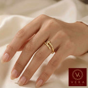 Hand wearing a women gold ring on a soft fabric background with Veka logo.