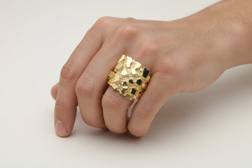 Gold ring with a textured NUgget design on a white background