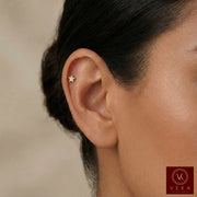 Close-up of an ear with a star-shaped earring, blurred background