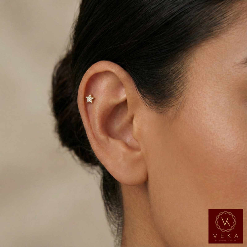 Close-up of an ear with a star-shaped earring, blurred background