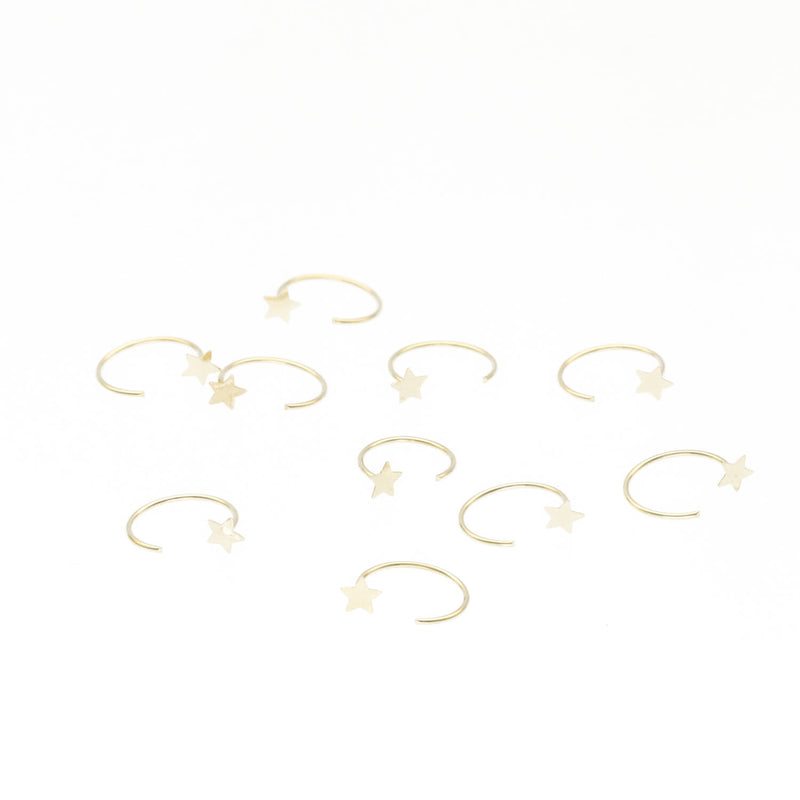 14k yellow gold open nose hoop featuring a tiny star accent. Minimalist gold nose piercing jewelry by VEKA Jewelry