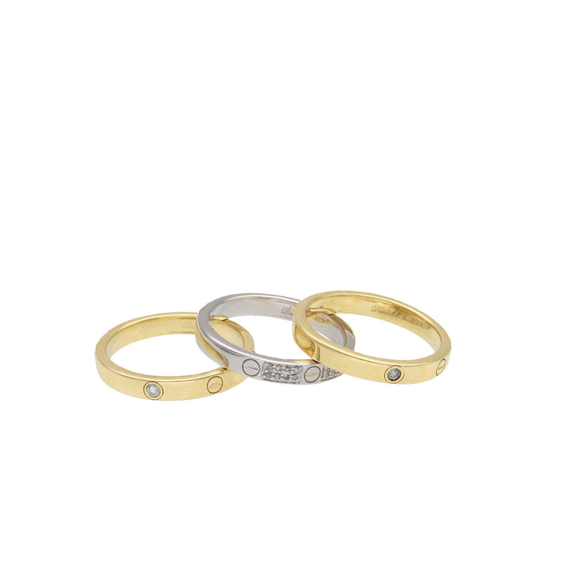Three gold and white gold rings stacked on a white background