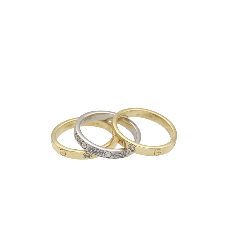 Three gold diamond screw head style men rings stacked on a white background