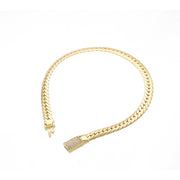 Top view of a 14K yellow gold hollow link bracelet on a white background showing the cubic zirconia encrusted push-in clasp.