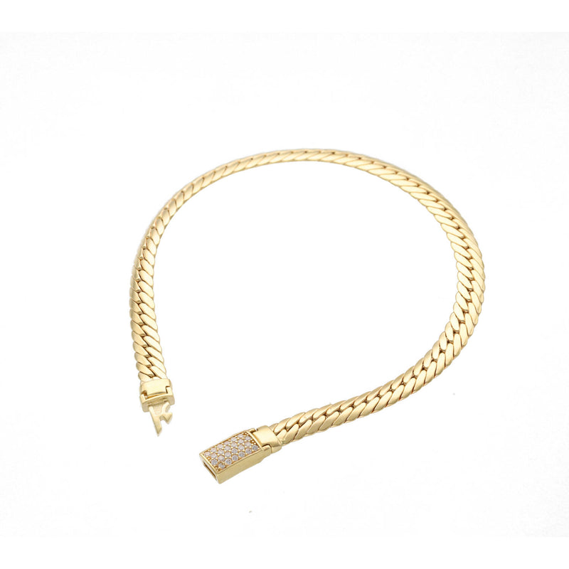 Top view of a 14K yellow gold hollow link bracelet on a white background showing the cubic zirconia encrusted push-in clasp.