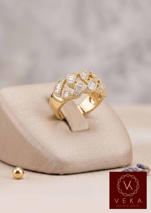 Men's 10k yellow gold Cuban link ring featuring channel-set baguette diamonds and round brilliant accents on a professional jewelry display