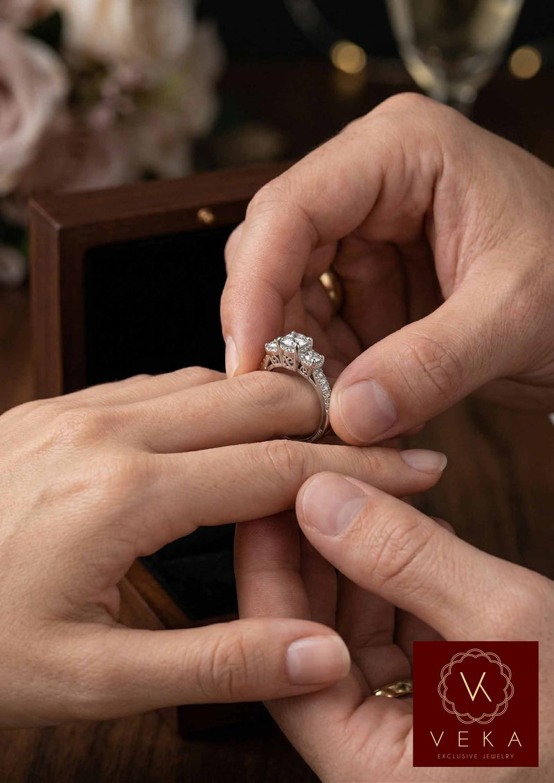 Man sliding a white gold three-stone natural diamond ring onto a woman's finger during a proposal