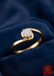 Close up of a polished 14K gold fleur promise ring with natural diamond cluster on a blue velvet background.