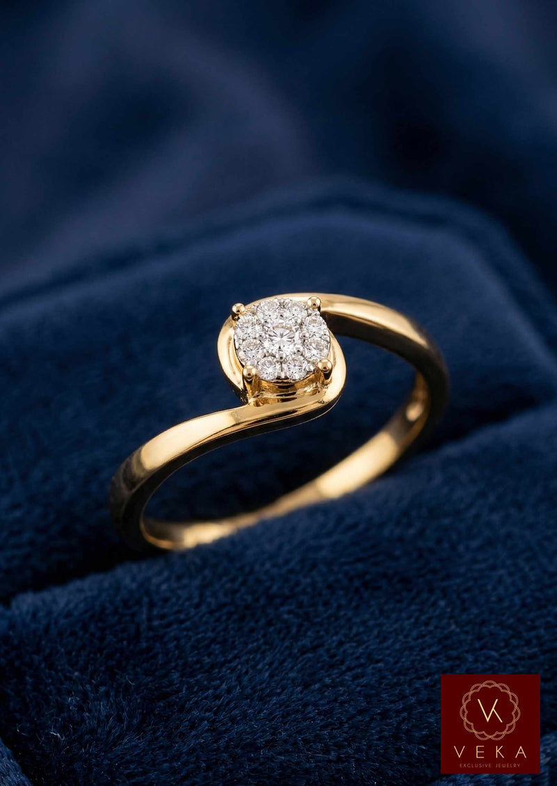 Close up of a polished 14K gold fleur promise ring with natural diamond cluster on a blue velvet background.