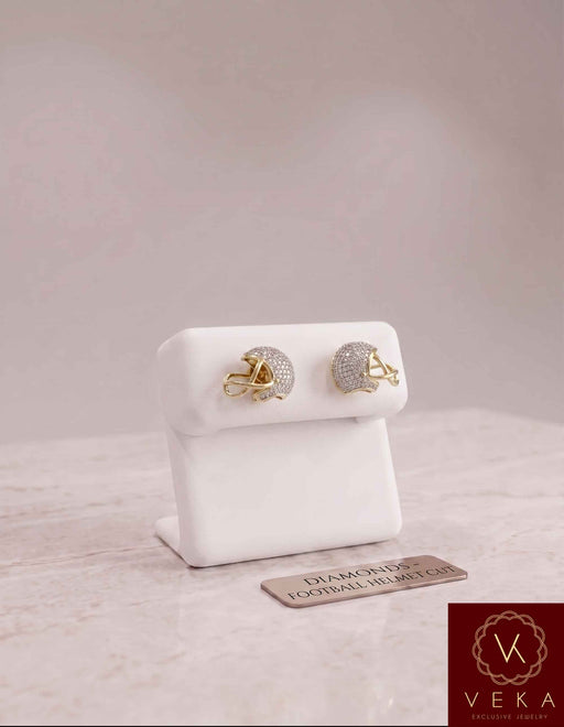 Pair of 10k gold and natural diamond football helmet stud earrings presented on a white jewelry display stand.