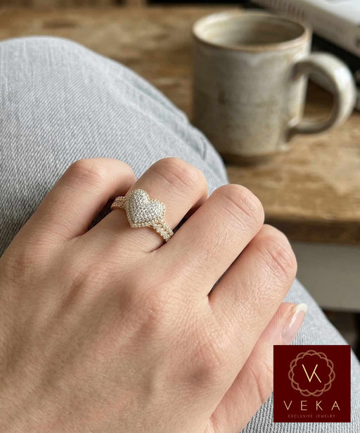Woman wearing a heart-shaped diamond cluster ring with a Cuban link style band in a casual setting, professional jewelry photography