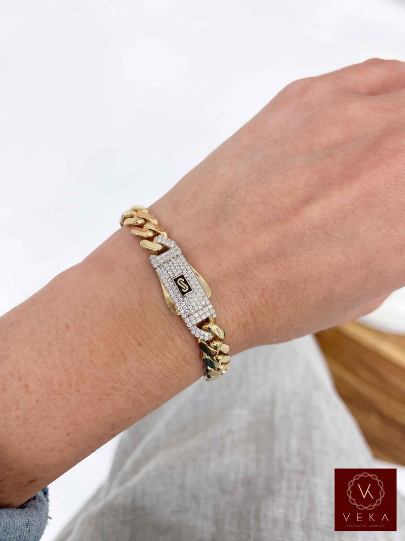 Male model showcasing a layered look with real 14K gold Monaco Chain™ Miami Cuban link 9 mm wide bracelet with pavé lock  by Veka Jewelry.