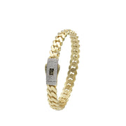 Detailed close-up of a hollow 10k gold Monaco bangle, showing the high-polish finish and secure Swarovski fastener