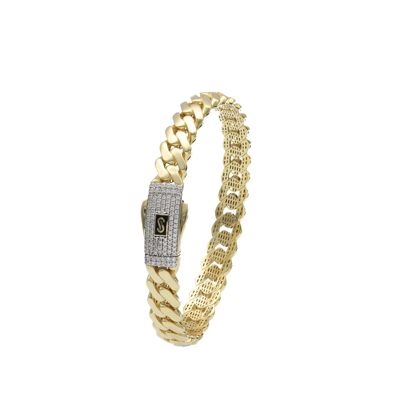 Detailed close-up of a hollow 10k gold Monaco bangle, showing the high-polish finish and secure Swarovski fastener