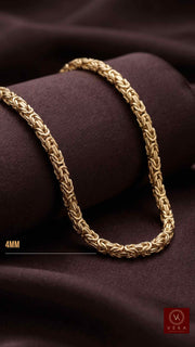 A polished 14k solid yellow gold Byzantine necklace draped elegantly on a dark, plush chocolate brown velvet surface, highlighting the metal's color and shine.