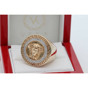 A frontal view of the substantial men's solid 10k gold signet ring. It details the Medusa head motif and the precision-set natural diamond pavé halo with a continuous Greek meander pattern. The ring is beautifully presented in a red jewelry display box