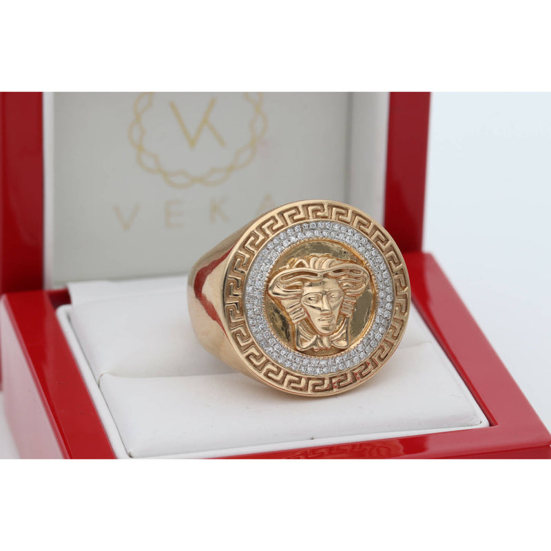 The elegant 10k yellow gold Medusa statement ring by Veka Jewelry, featuring a central Medusa emblem and 1/3 ctw diamond halo, is nested securely in a professional, fabric-lined red presentation gift box. The 'Veka' brand logo is subtly visible on the internal lining
