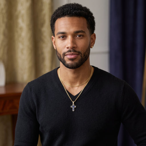 Male model wearing a 14K yellow gold blue enamel cross pendant on a thin gold Cuban chain layered with a solid gold chain