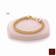 Men's 10K yellow gold 6mm semi-solid Franco chain bracelet on a luxury display cushion by Veka Jewelry