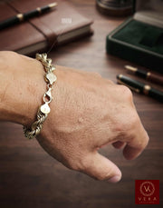Man wearing an 8mm hollow 10K yellow gold rope bracelet on his wrist from the Veka Jewelry collection