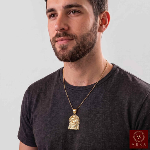 Male model wearing the 10K yellow gold Jesus face pendant on a gold chain necklace for men by Veka Jewelry