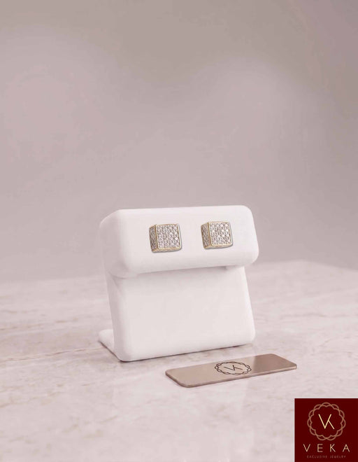 Men's 10K gold square diamond cluster stud earrings showcased on a luxury white display stand by Veka Jewelry.