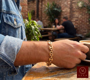 Lifestyle view of a man wearing the 9mm 14K yellow gold puff mariner link bracelet by Veka Jewelry