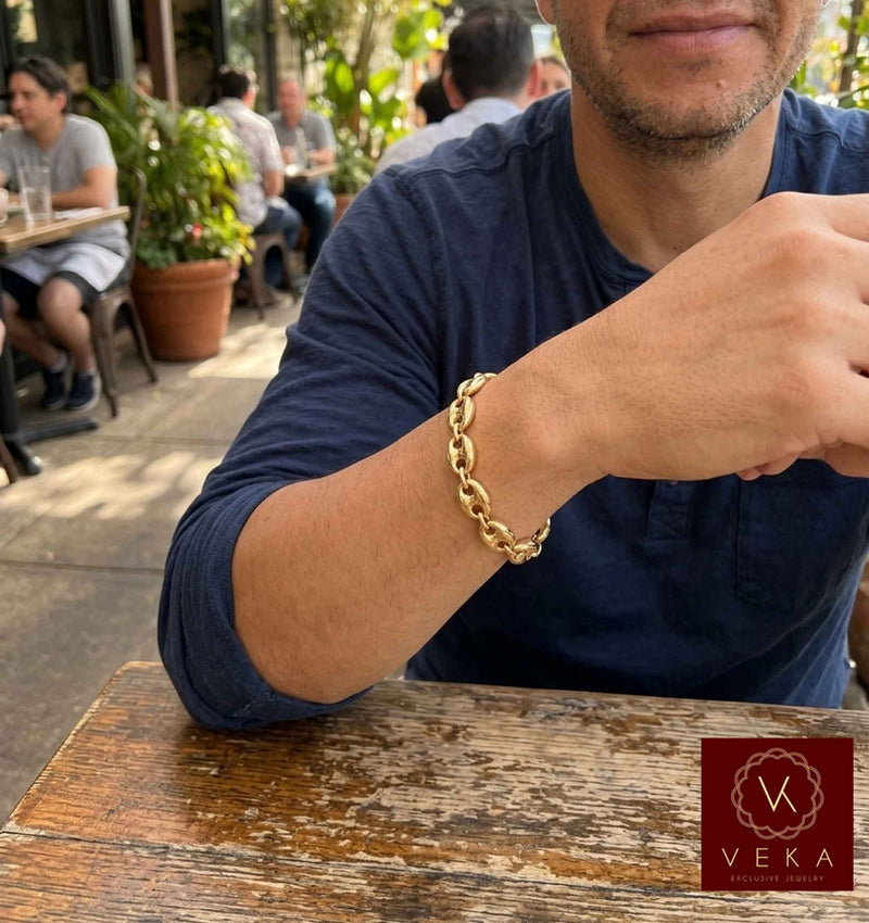 Lifestyle view of a man wearing the 12mm 14K yellow gold puff mariner link bracelet by Veka Jewelry