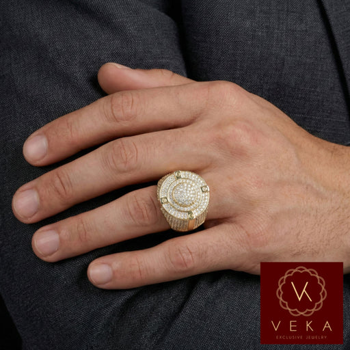 A male model's hand wearing the heavy 14k yellow gold and cubic zirconia iced-out ring on the ring finger, resting against a dark grey suit fabric, showing the ring's impressive scale and sparkle.