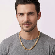 A man modeling a thick 14k solid gold Byzantine link chain necklace by Veka Jewelry, showing length and scale against a casual t-shirt.