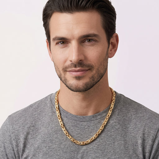A man modeling a thick 14k solid gold Byzantine link chain necklace by Veka Jewelry, showing length and scale against a casual t-shirt.