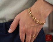 Lifestyle view of a man wearing the 8mm 14K yellow gold puffed mariner link bracelet by Veka Jewelry