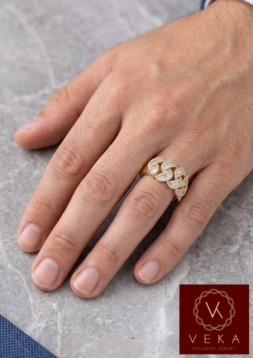 Close-up of a man's hand wearing a wide gold Cuban chain style ring set with diamonds, luxury lifestyle jewelry photography.