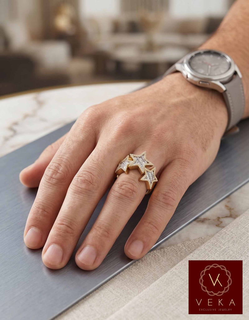 Male model wearing a handcrafted 10K yellow gold triple star diamond ring with 0.65 CTW, styled with a luxury watch and casual gray background.