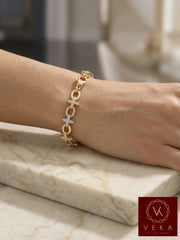 Professional model wearing a 10k yellow gold star charm bracelet in a casual setting on a marble table, highlighting the 7.5-inch fit and oversized lobster closure