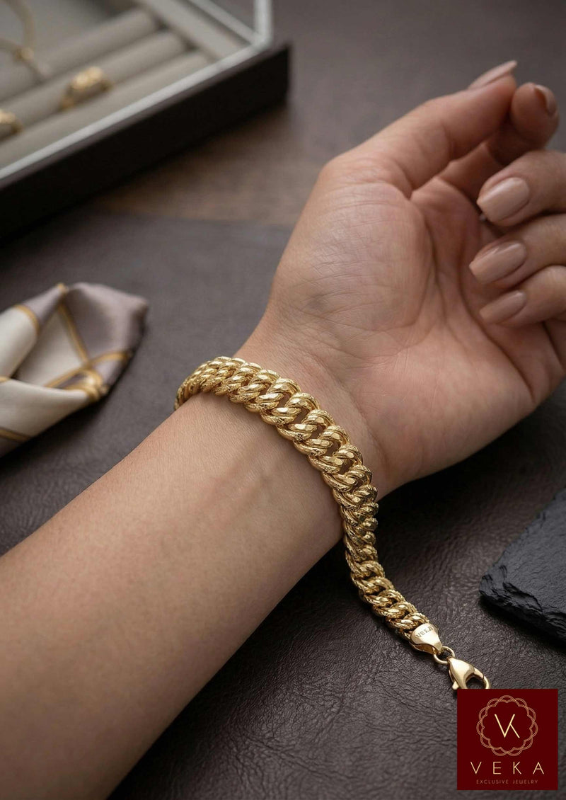 Lifestyle image of a model wearing a tapered 10K yellow gold princess link bracelet from Veka Jewelry