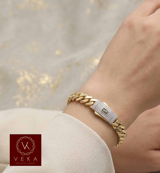 Authentic Monaco 10k yellow gold Miami link bangle with a Swarovski encrusted box clasp on a woman's wrist